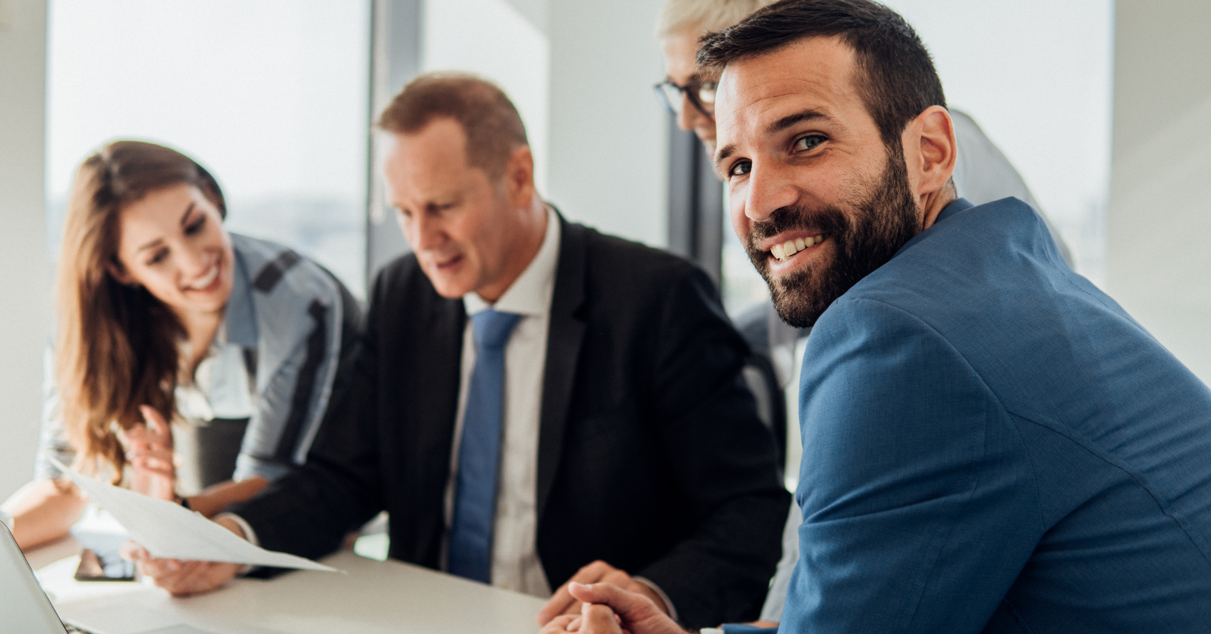Legal professionals reviewing documents together during a meeting, representing outside counsel evaluation and firm selection.