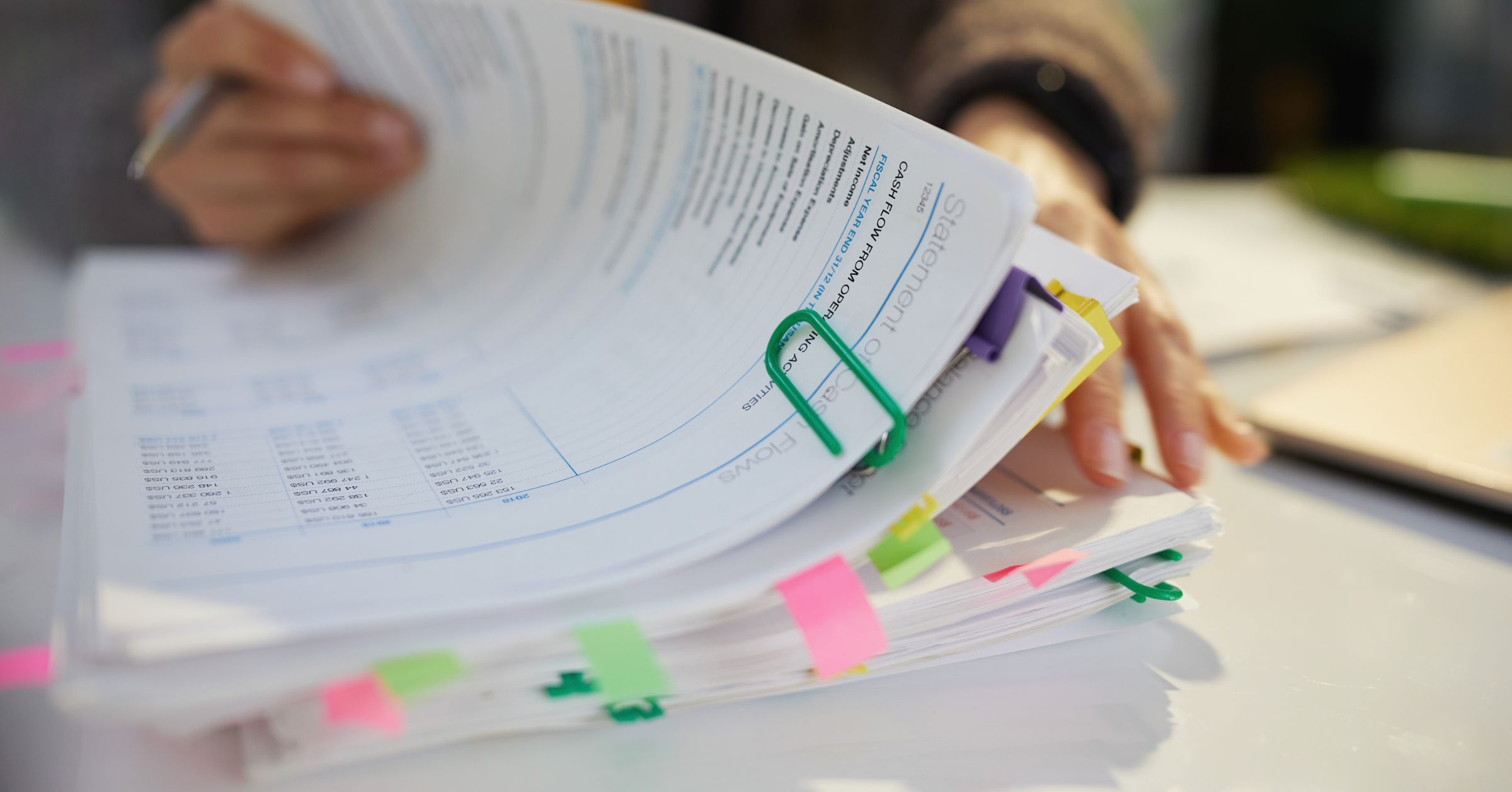A legal operations or finance professional reviewing an invoice on screen next to a printed billing guidelines document, in a polished modern office setting. Avoid robots, glowing AI brains, gavels, and generic courthouse imagery.